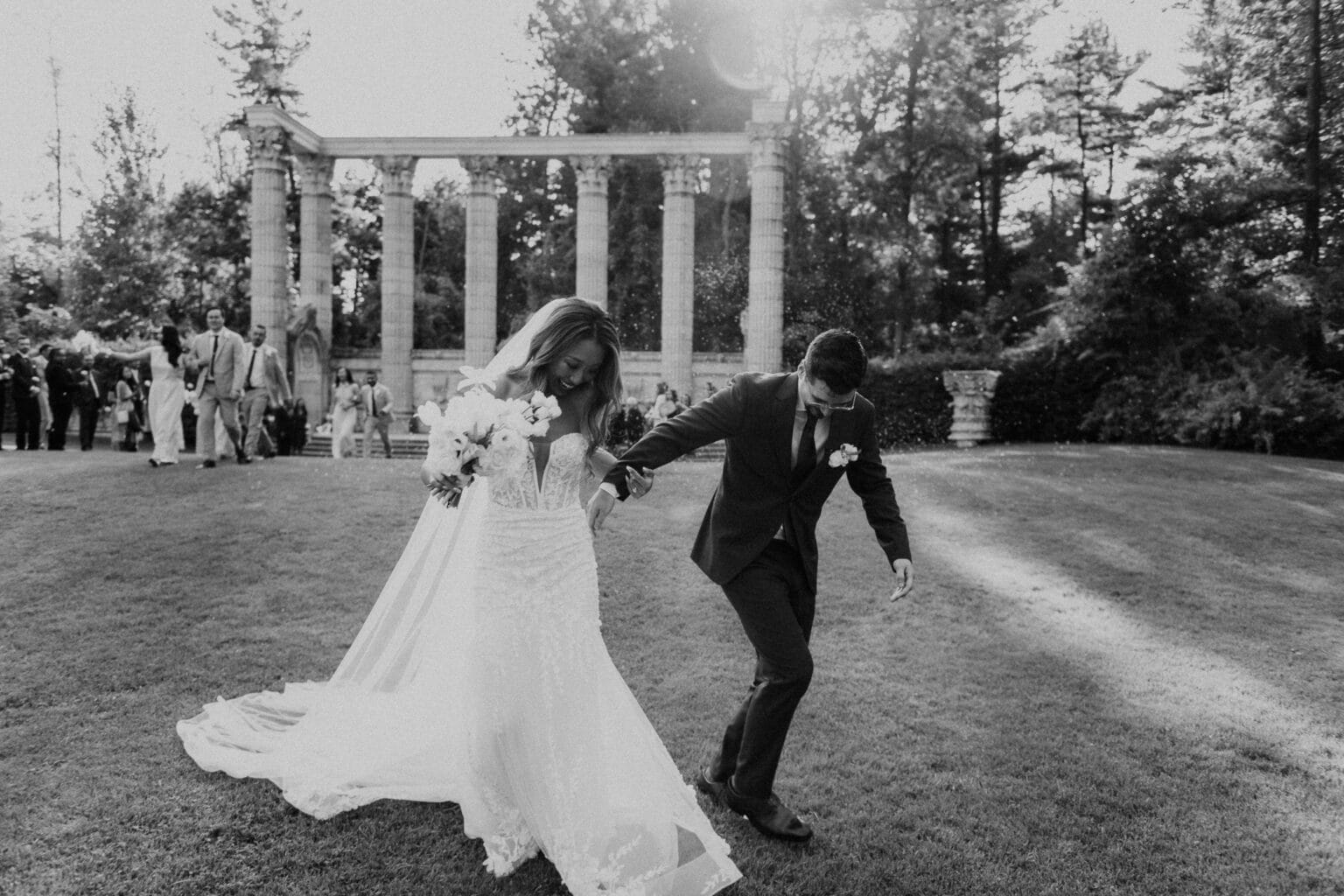 Black and white candid photo of couple exciting the ceremony.